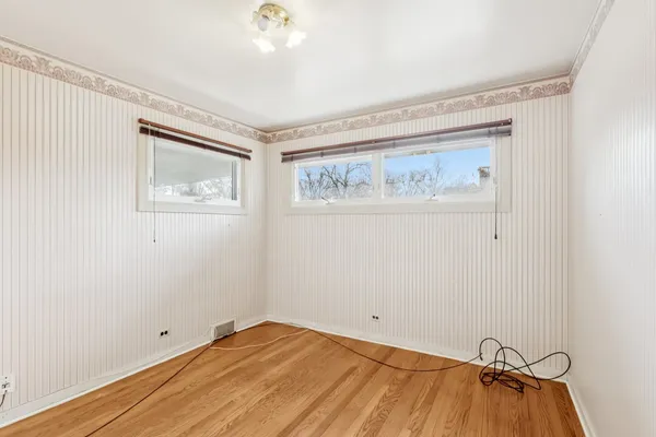 a view of room with window and wooden floor