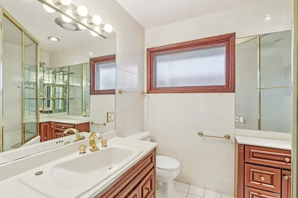 a bathroom with a sink vanity granite toilet and a mirror