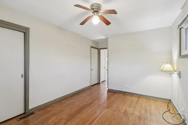 a view of a room with wooden floor and a ceiling fan