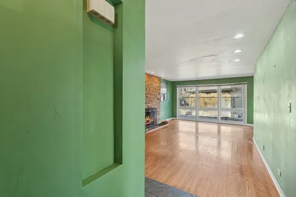 a view of empty room with wooden floor and fan