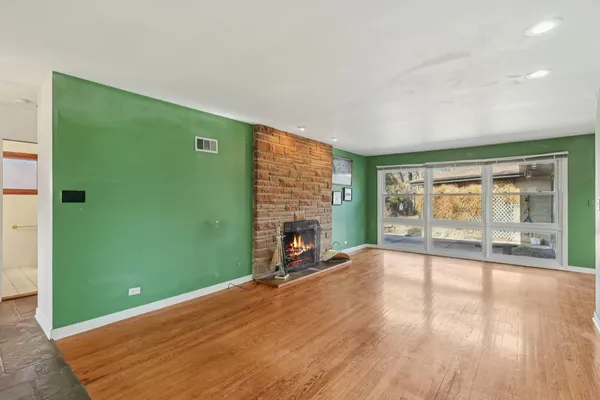 a view of an empty room with a fireplace and a window