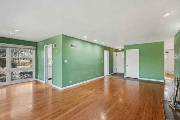 a view of an empty room with wooden floor