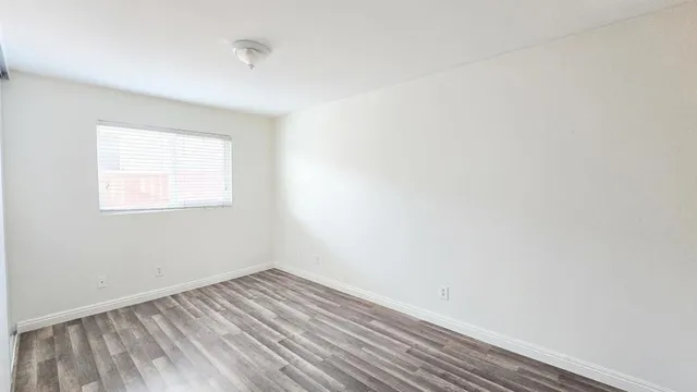 a view of a room that has wooden floor and white walls