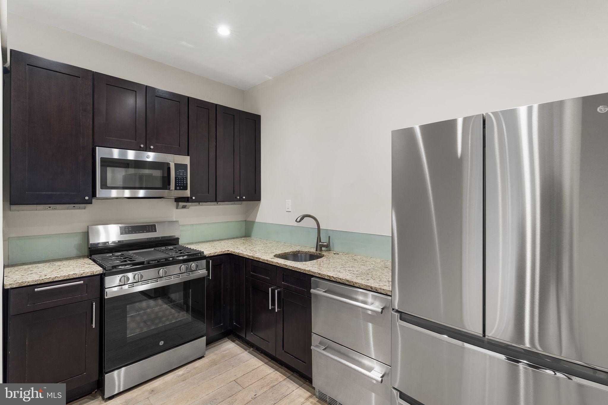 1830 Rittenhouse Square, Unit 1C Philadelphia, PA 19103 - Photo 11 of 32 a kitchen with stainless steel appliances granite countertop a refrigerator stove and microwave