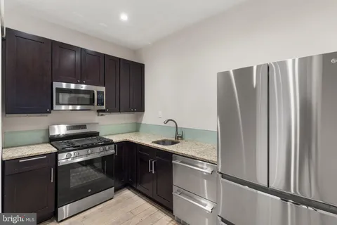 a kitchen with stainless steel appliances granite countertop a refrigerator stove and microwave