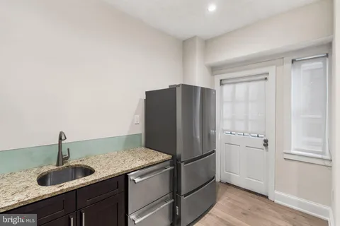a kitchen with granite countertop a refrigerator and cabinets