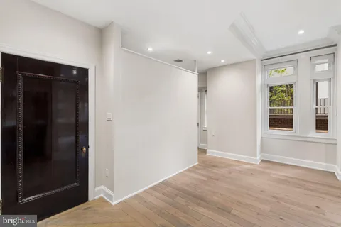 a view of hallway with windows and wooden floor