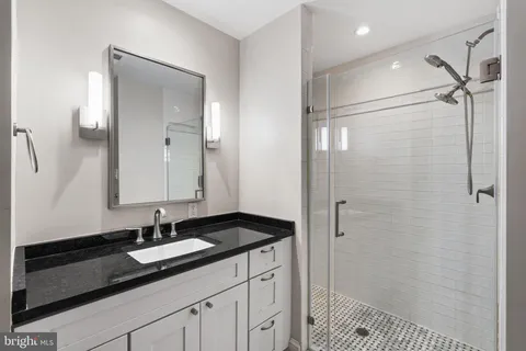 a bathroom with a shower sink vanity and mirror