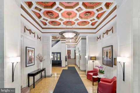 a hallway with a couch and chandelier