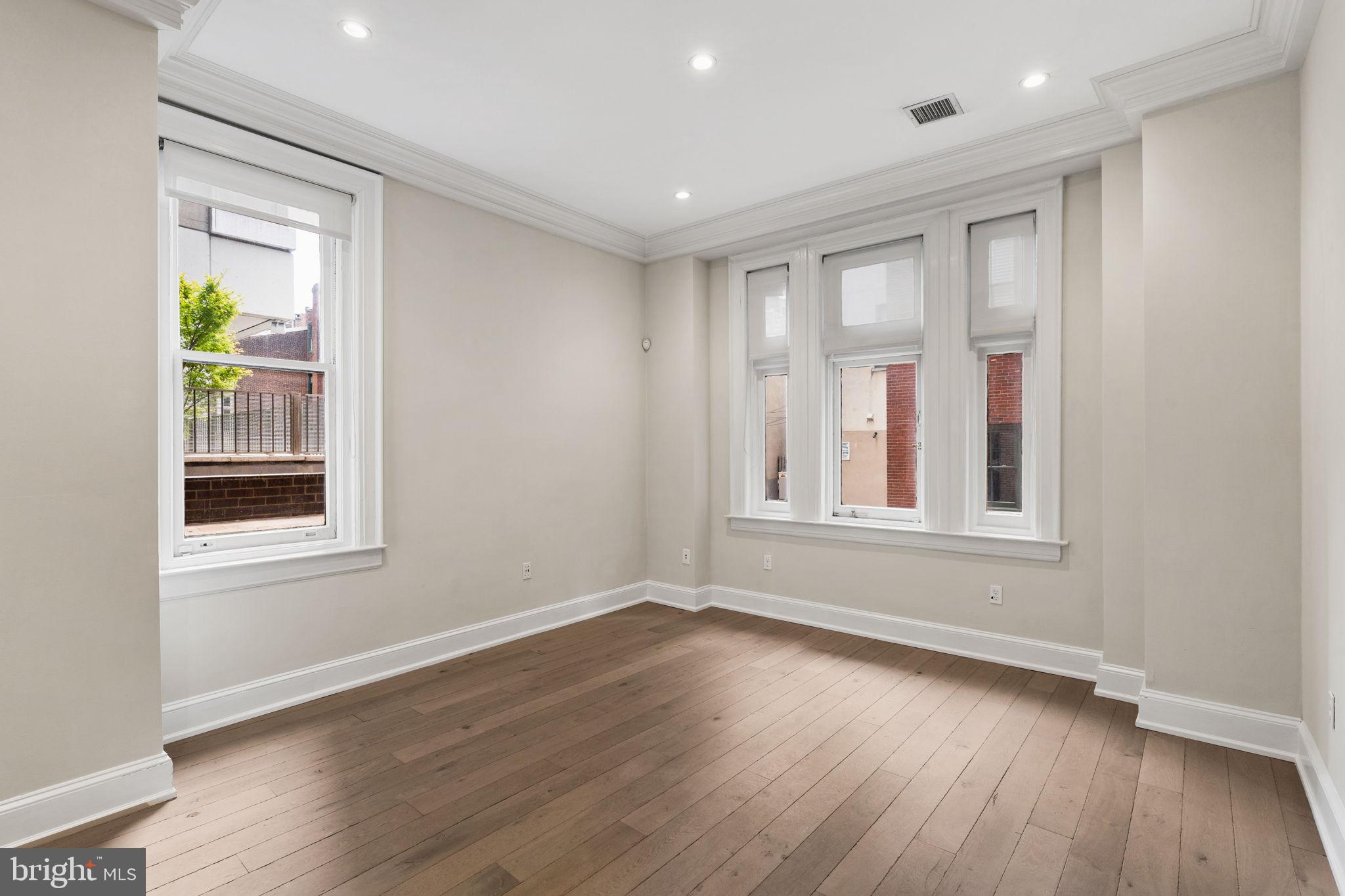 1830 Rittenhouse Square, Unit 1C Philadelphia, PA 19103 - Photo 4 of 32 a view of an empty room with wooden floor and a window