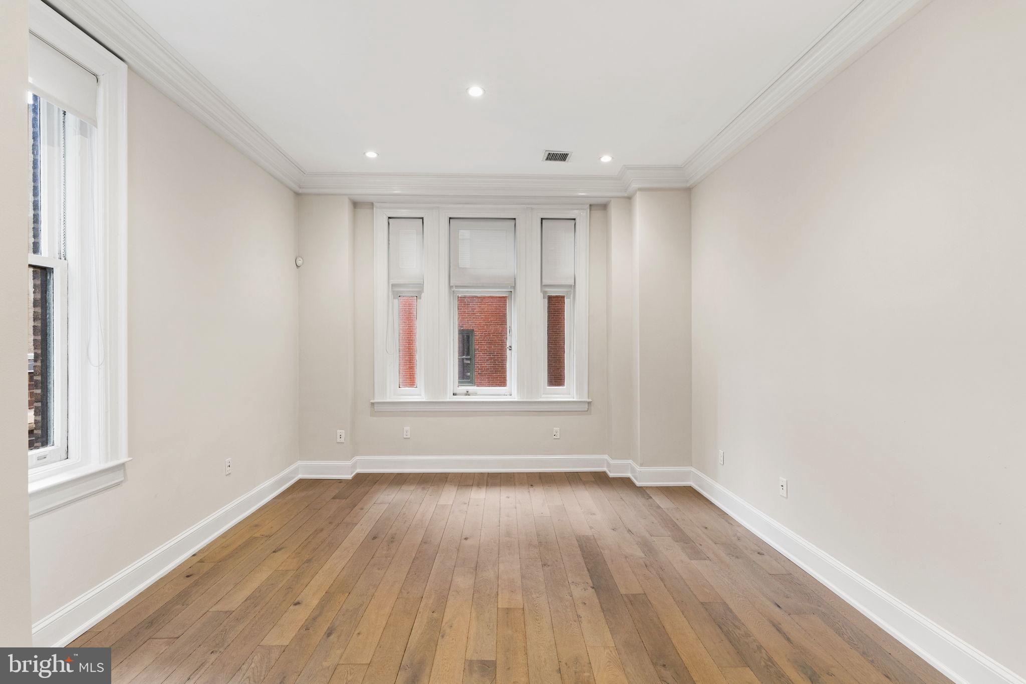 1830 Rittenhouse Square, Unit 1C Philadelphia, PA 19103 - Photo 6 of 32 a view of empty room with wooden floor and fan