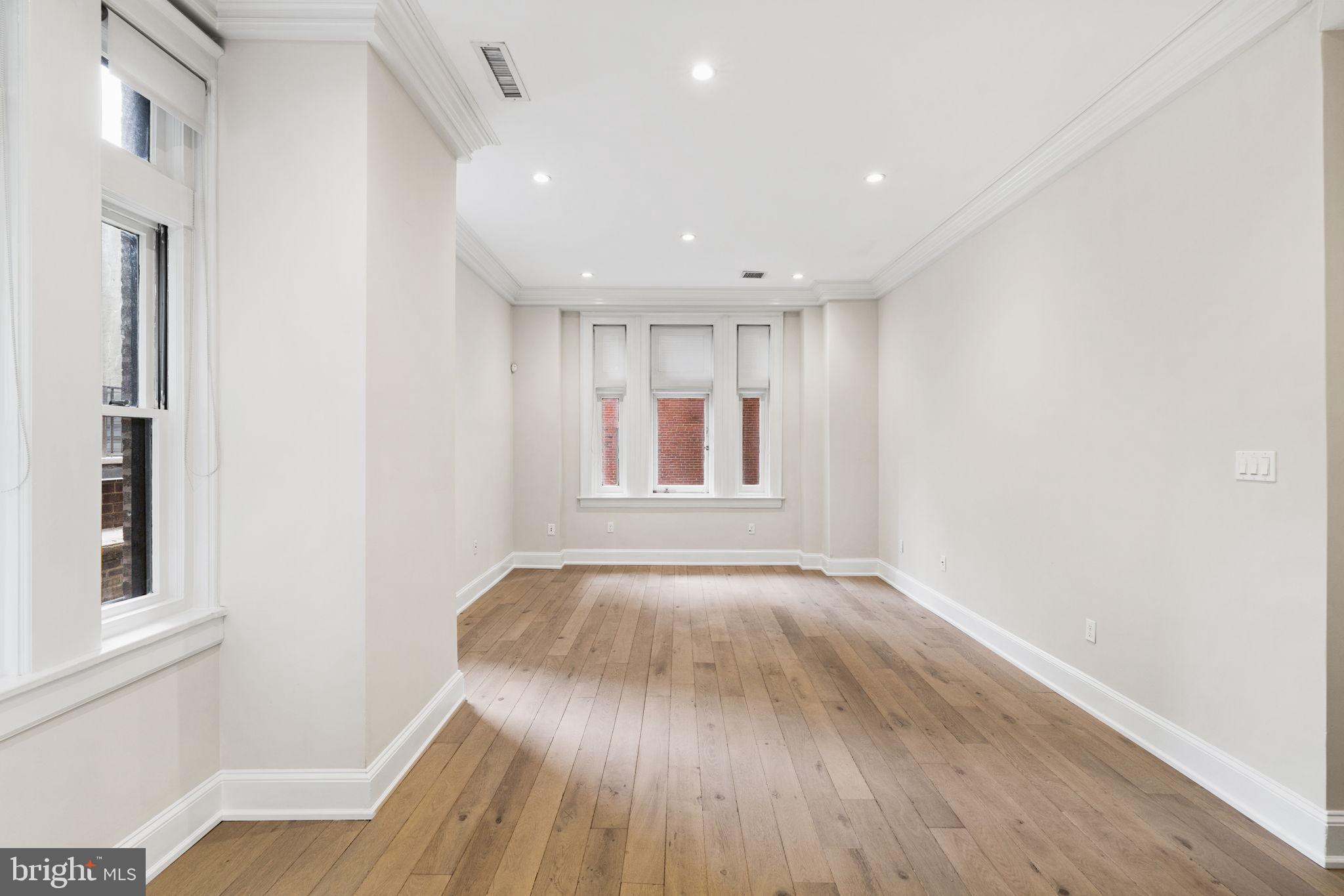 1830 Rittenhouse Square, Unit 1C Philadelphia, PA 19103 - Photo 6 of 32 a view of an empty room with wooden floor and a window