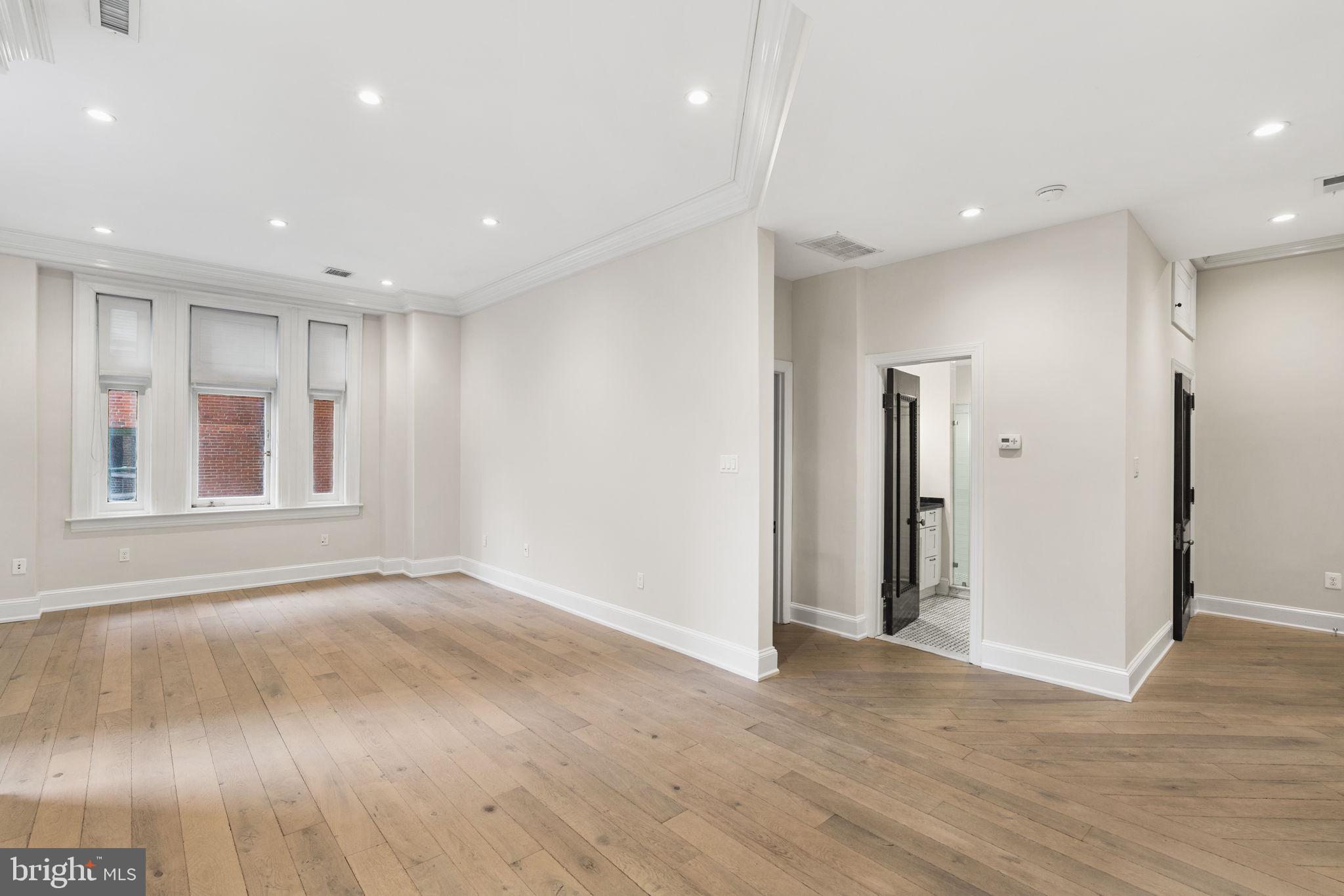 1830 Rittenhouse Square, Unit 1C Philadelphia, PA 19103 - Photo 7 of 32 a view of an empty room with wooden floor and a window