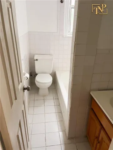 a white toilet sitting next to a bath tub