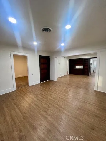 an empty room with wooden floor and natural light
