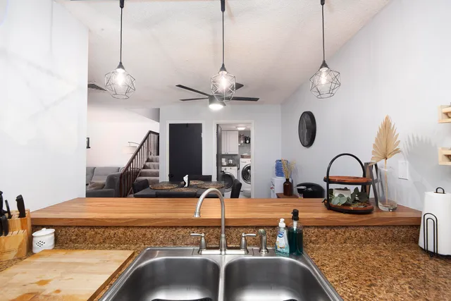 a kitchen with a faucet a chandelier and living area view