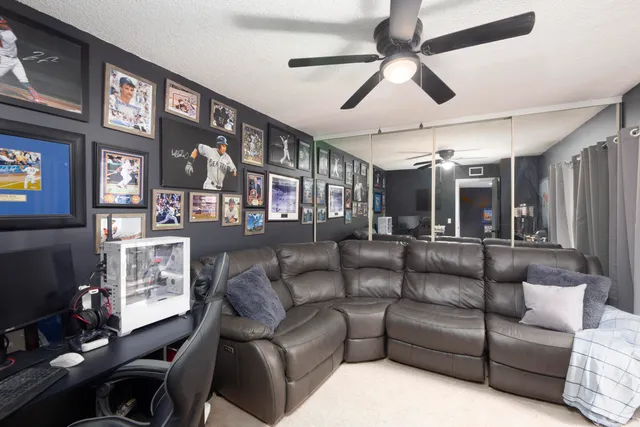 a living room with furniture a ceiling fan and a window