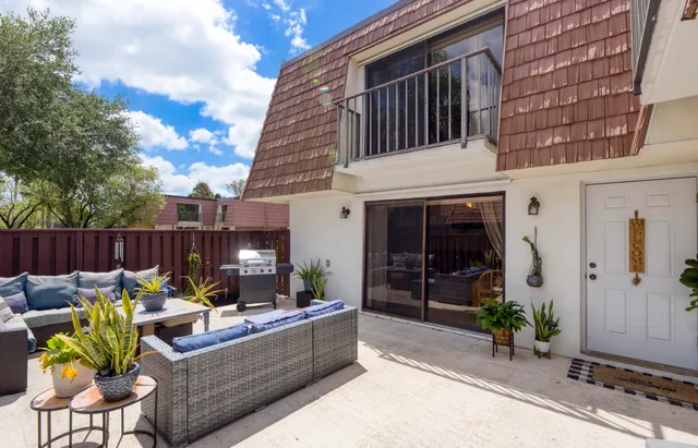 a view of a patio with couches chairs and potted plants