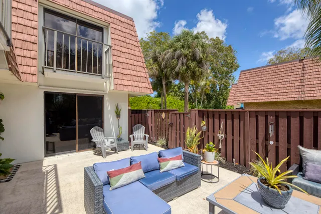 a view of a patio with table and chairs potted plants and wooden fence