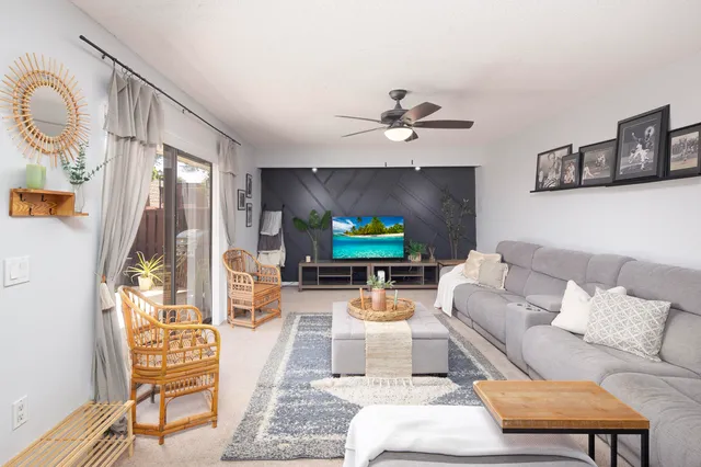 a living room with furniture a flat screen tv and a large window