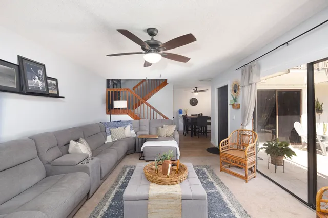 a living room with furniture and a ceiling fan