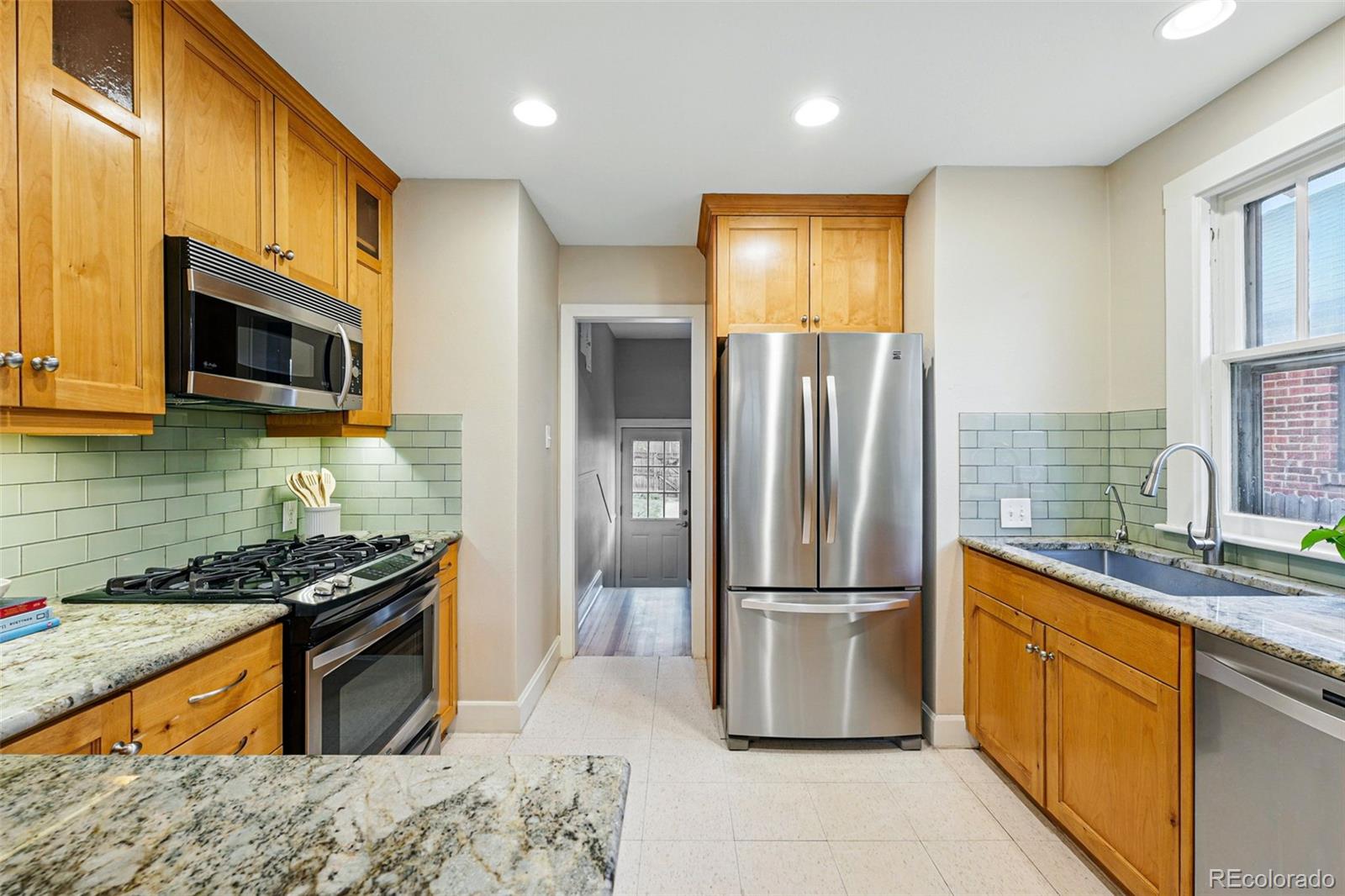 1312 Ash Street Denver, CO 80220 - Photo 14 of 31 a kitchen with stainless steel appliances granite countertop a refrigerator a stove top oven a sink and dishwasher