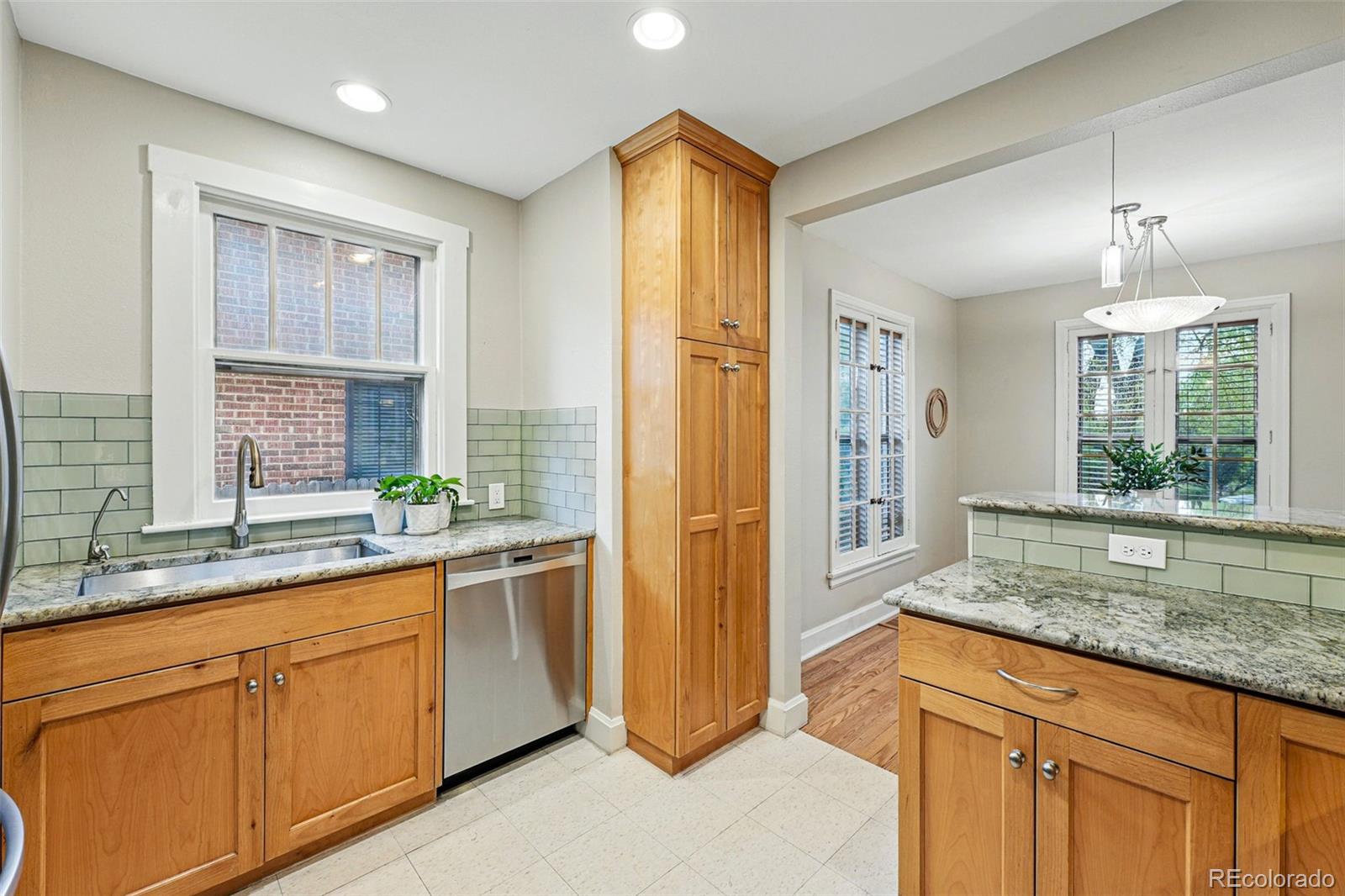 1312 Ash Street Denver, CO 80220 - Photo 16 of 31 a kitchen with stainless steel appliances granite countertop a refrigerator a sink dishwasher and wooden cabinets with wooden floor