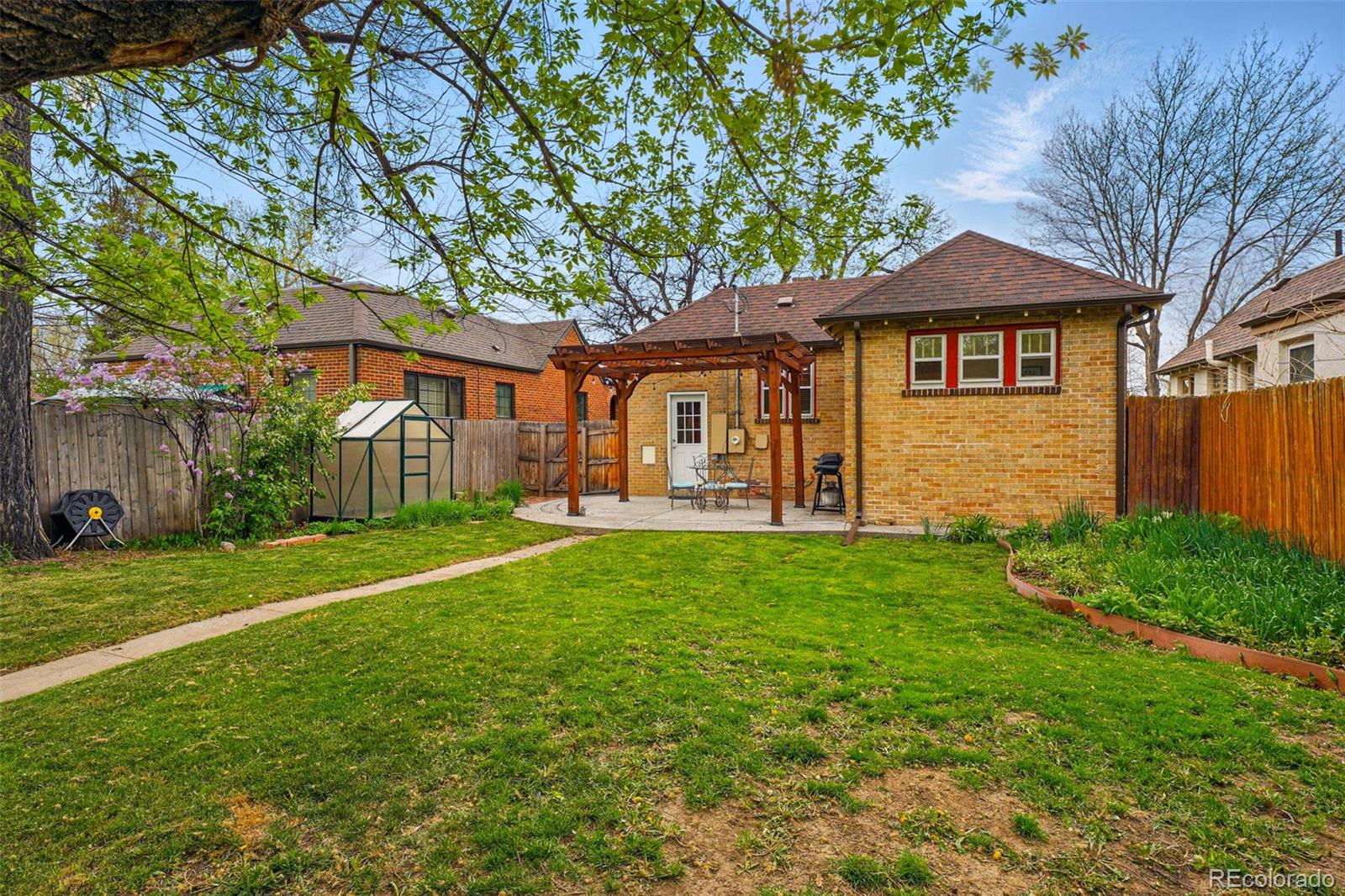 1312 Ash Street Denver, CO 80220 - Photo 31 of 31 a view of a yard in front of a house with large trees