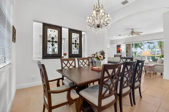 a dining room with furniture a chandelier and window