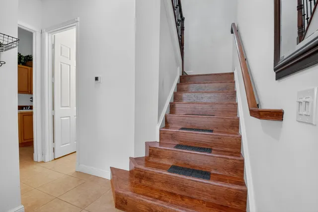 a view of a hallway with wooden floor and a bathroom