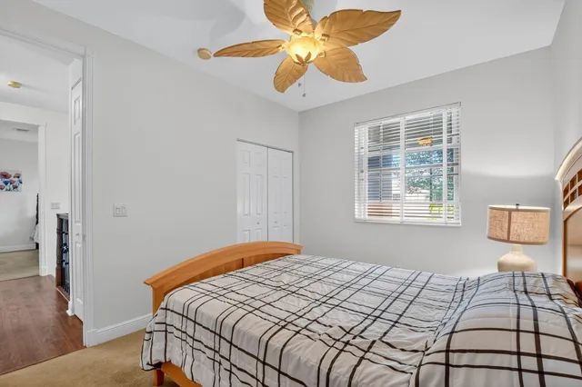 a front view of a house with a yard and palm trees
