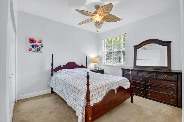 a room with lots of white furniture and chandelier