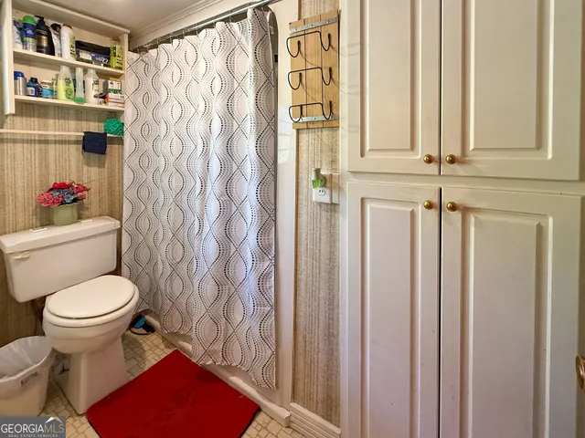 a bathroom with a toilet and a shower curtain