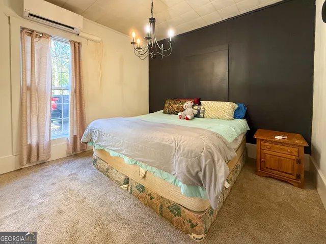a bedroom with a bed and a chandelier
