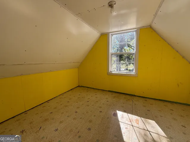 a view of a big room with wooden floor and windows