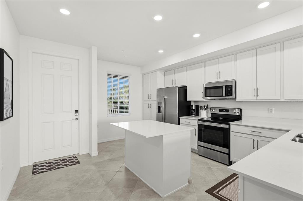 43985 Boardwalk Loop, Unit 2124 Punta Gorda, FL 33982 - Photo 15 of 80 a kitchen with stainless steel appliances a refrigerator stove microwave and white cabinets