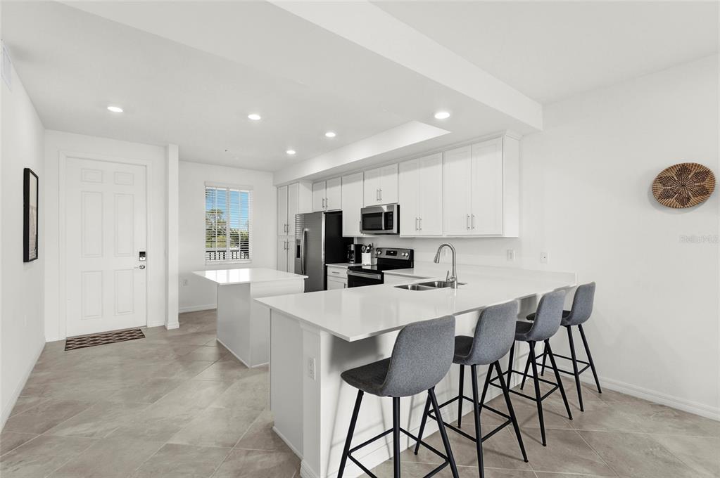 43985 Boardwalk Loop, Unit 2124 Punta Gorda, FL 33982 - Photo 3 of 80 a large white kitchen with a table and chairs