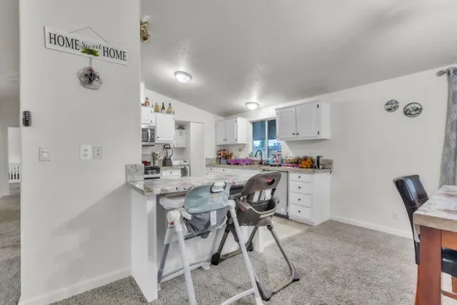 a living room with stainless steel appliances kitchen island granite countertop furniture and a refrigerator