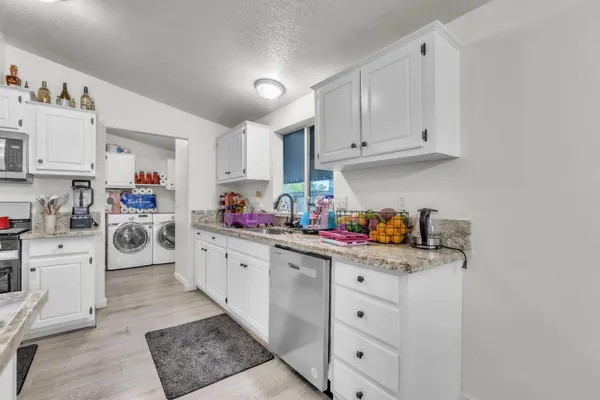 a kitchen with white cabinets and white appliances