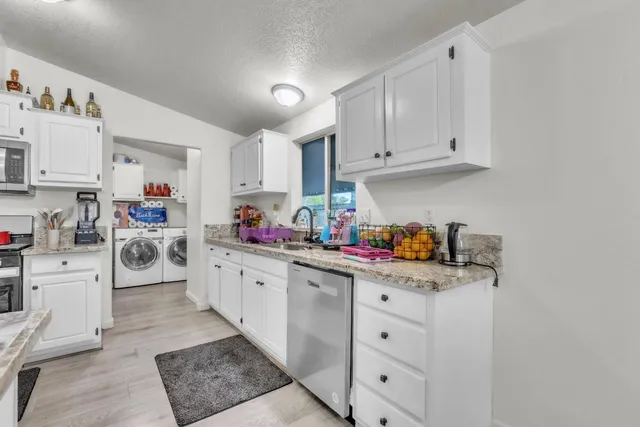 a kitchen with white cabinets and white appliances