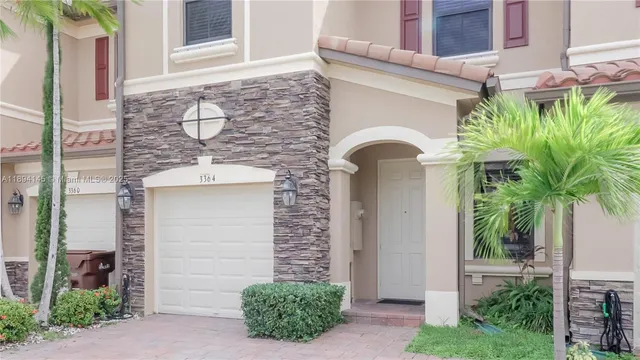 a front view of a house with plants