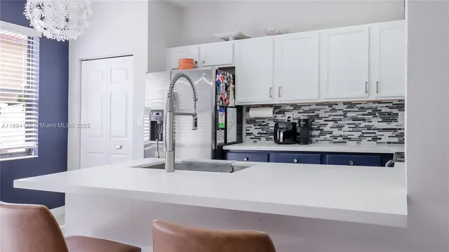 a kitchen with stainless steel appliances a sink and a refrigerator