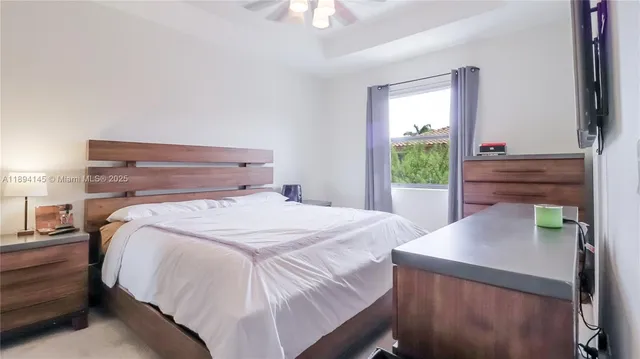 a bed sitting in a bedroom next to a window with dresser