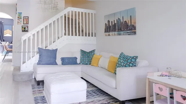 a living room with furniture and baby crib