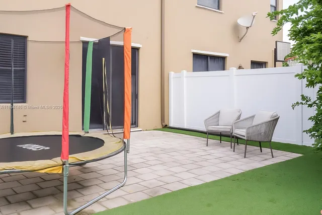 a backyard of a house with table and chairs