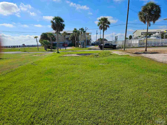 a view of pool with lawn chairs and a big yard