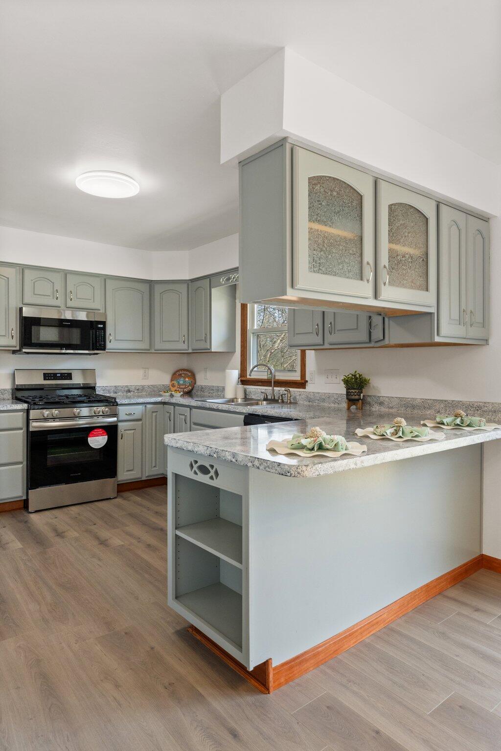 10473 North 493 East Demotte, IN 46310 - Photo 13 of 35 a kitchen with stainless steel appliances granite countertop a stove and a sink