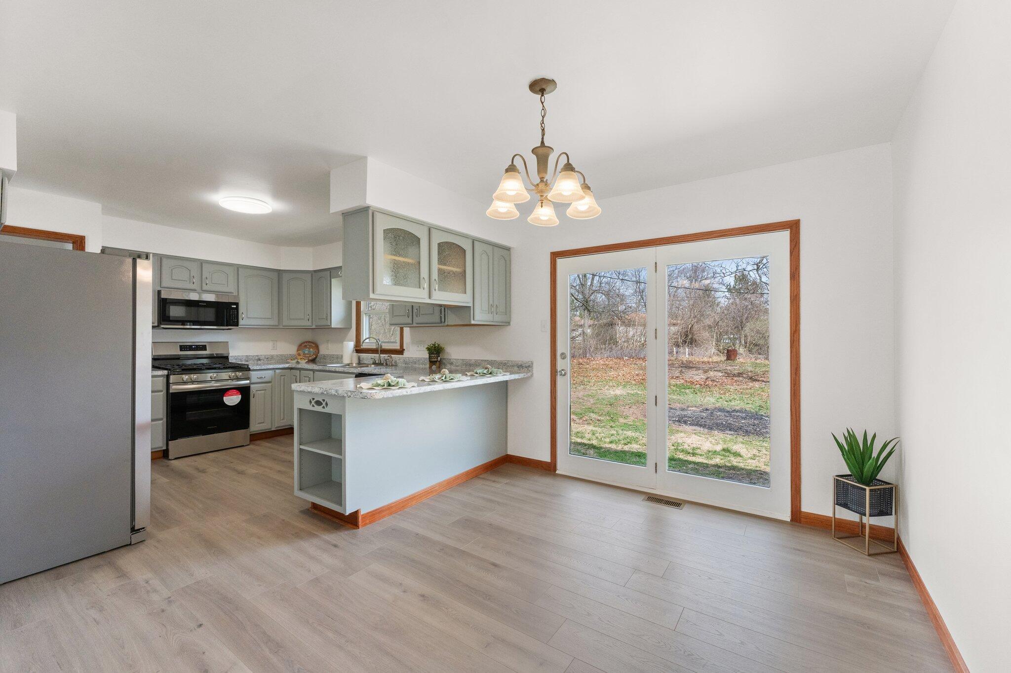 10473 North 493 East Demotte, IN 46310 - Photo 10 of 35 a open kitchen with stainless steel appliances granite countertop a stove top oven a refrigerator with island and wooden floor