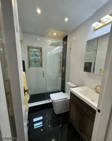 a bathroom with a sink a toilet a mirror and shower