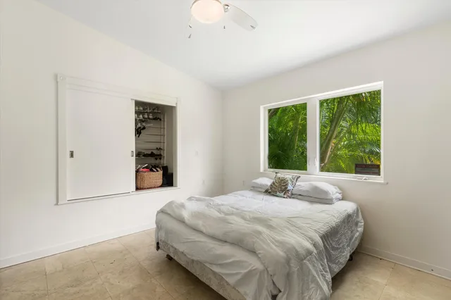 a bedroom with a bed and a large window